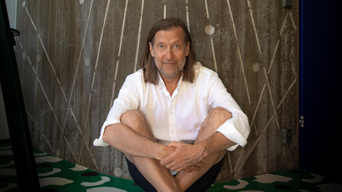 Henkilö risti-istunnassa katsomassa kameraan.