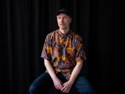 Olli Valkola istuu, poseeraa kameralle