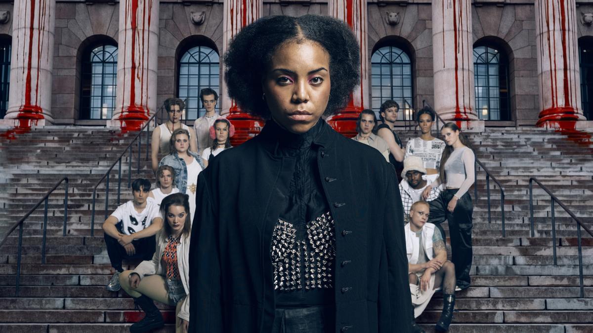 Kuvassa yksi henkilö etualalla, taustalla Eduskuntatalon portaat ja muita ihmisiä.