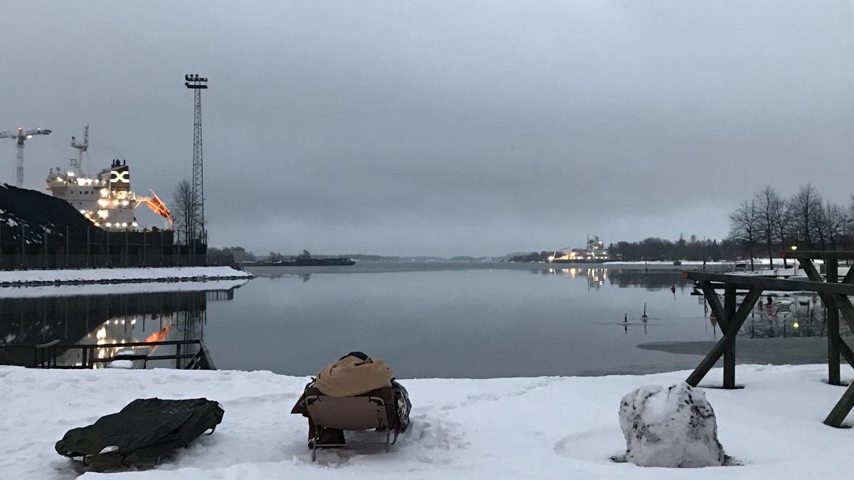 Kuva lumiselta rannalla, edessä sula meri.