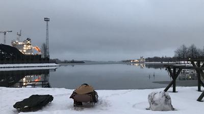 Kuva lumiselta rannalla, edessä sula meri.