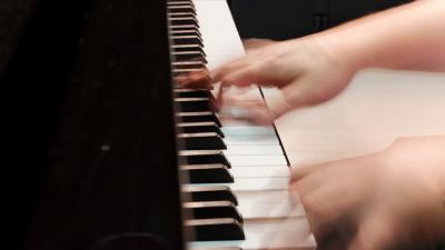 Kädet pianon koskettimilla