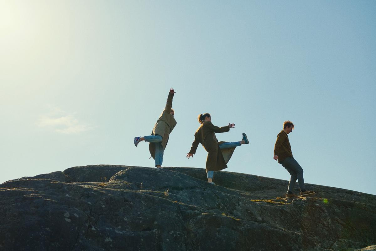 students are walking on a big rock.