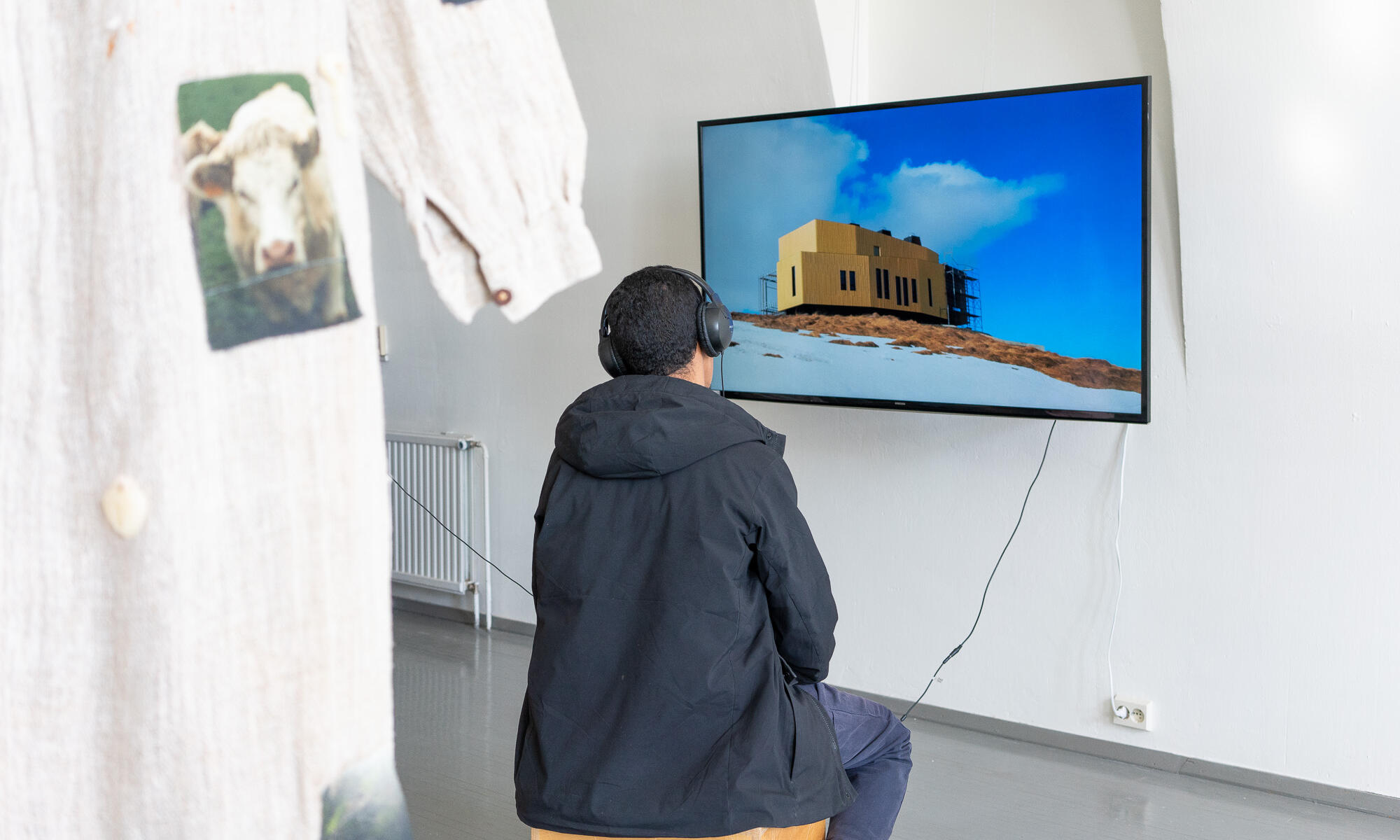 A person among art works is watching a screen in Research Pavilion exhibition.