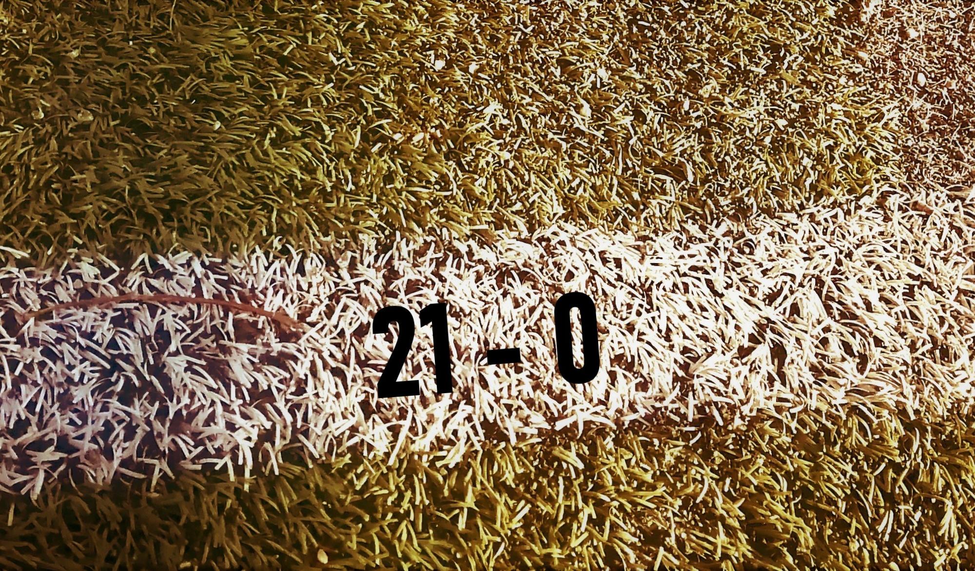 Jalkapallokentän valkoisen viivan päällä numerot 21 -0.