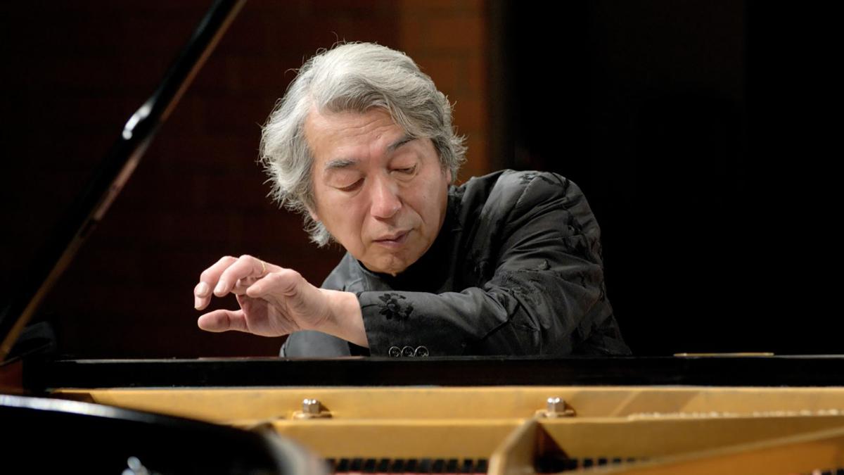 Izumi Tateno spelar piano. Han tittar på pianotangentborden.