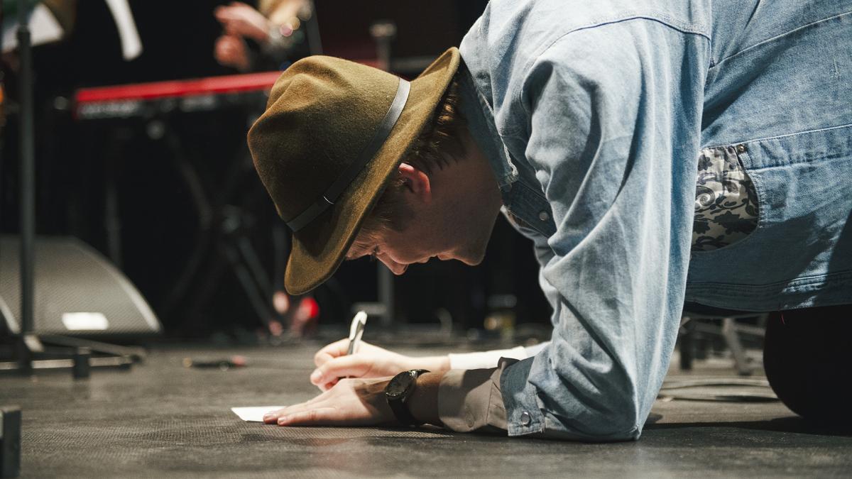 En man skriver på golvet.