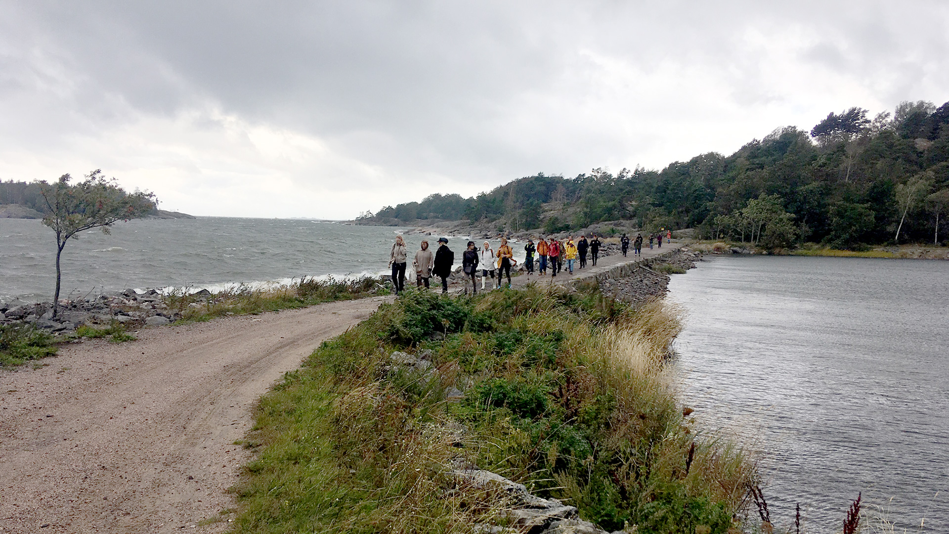 People crossing a neck of land between Vallisaari and Kuninkaansaari islands.