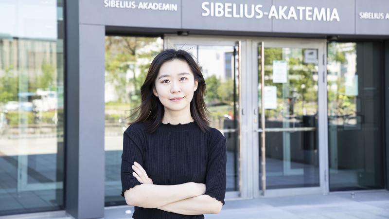Adele Xiang standin in front of the Sibelius Academy's entrance.
