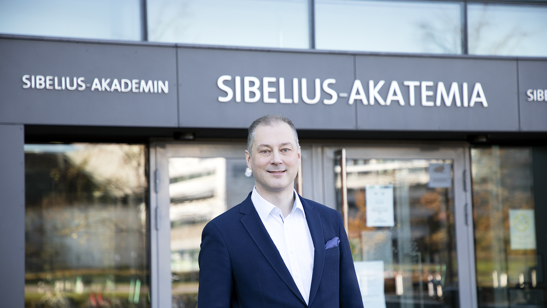 Olli-Pekka Martikainen in front of a Sibelius Academy building.