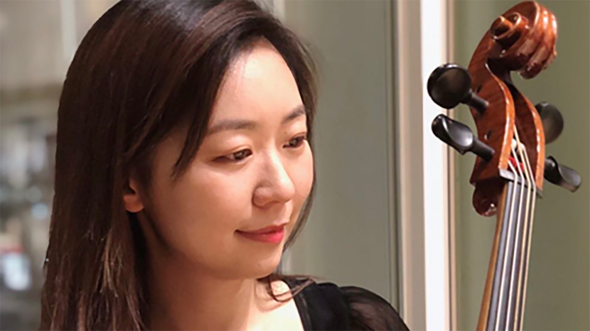 Adele Xiang is smiling while holding her cello.