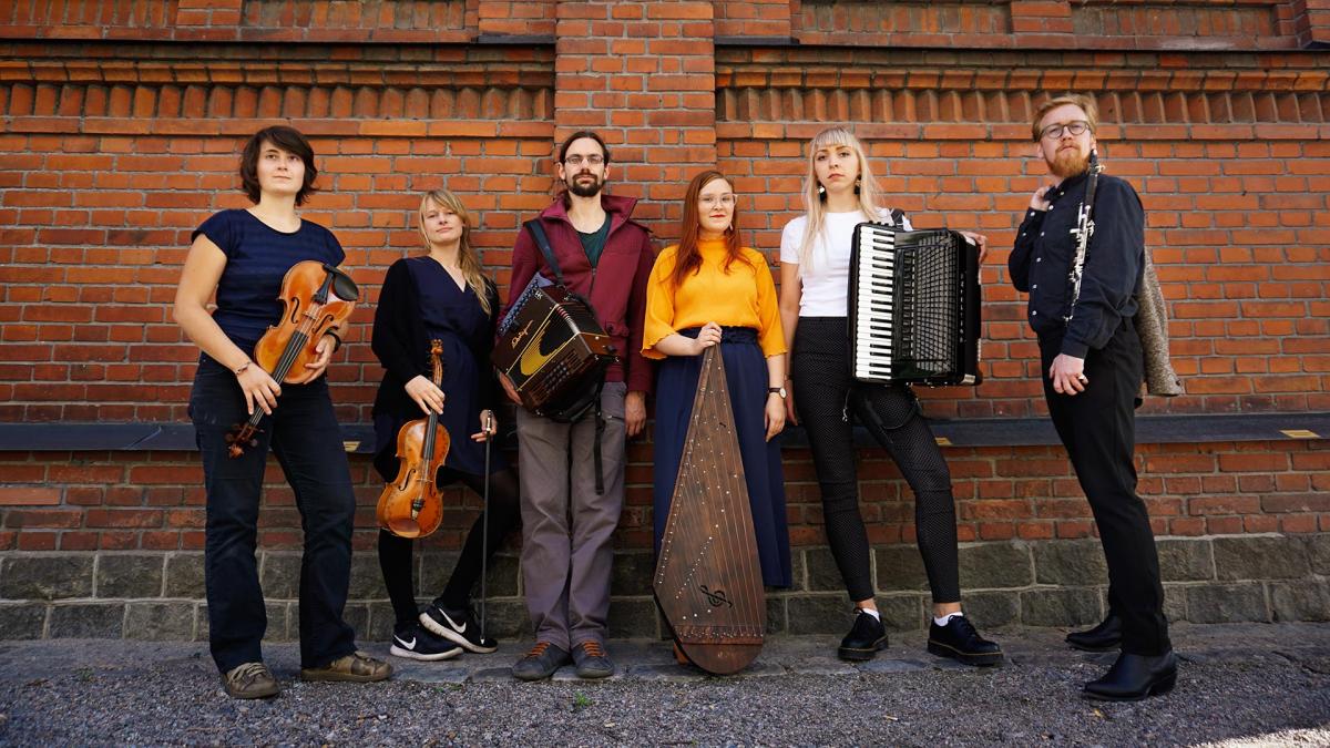 The GROV band is posing in front of a brick building.