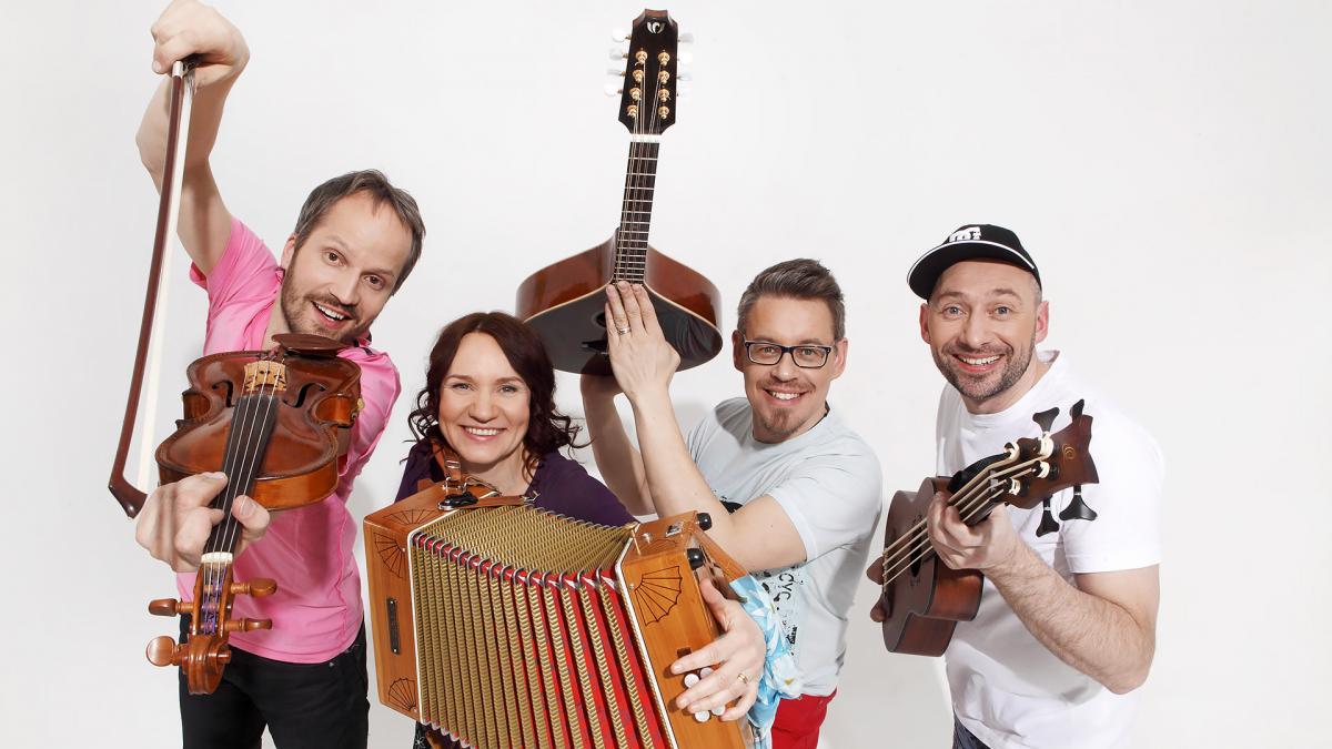 Freija is posing at studio with their instruments. Everyone is happy. Background of the photo is basic white.