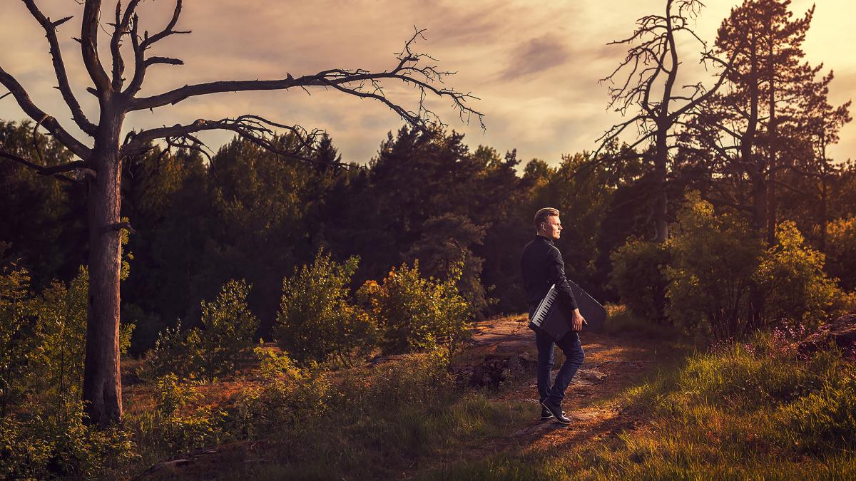 Aki Rissanen walks around forest.