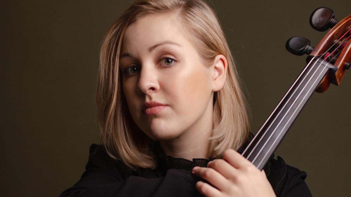 Senja Rummukainen poses with her cello on a studio. Face portrait.