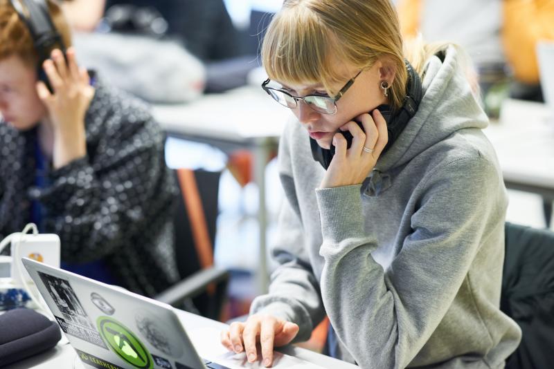 student with a laptop, looking at the laptop screen