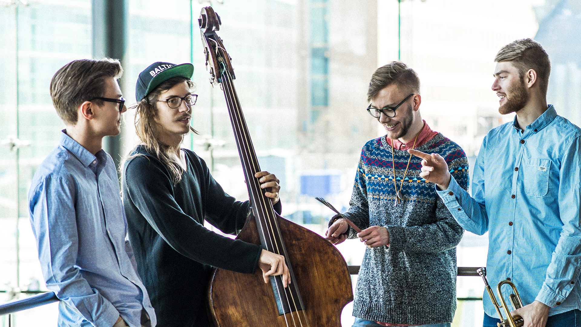 Four smiling students with instruments.