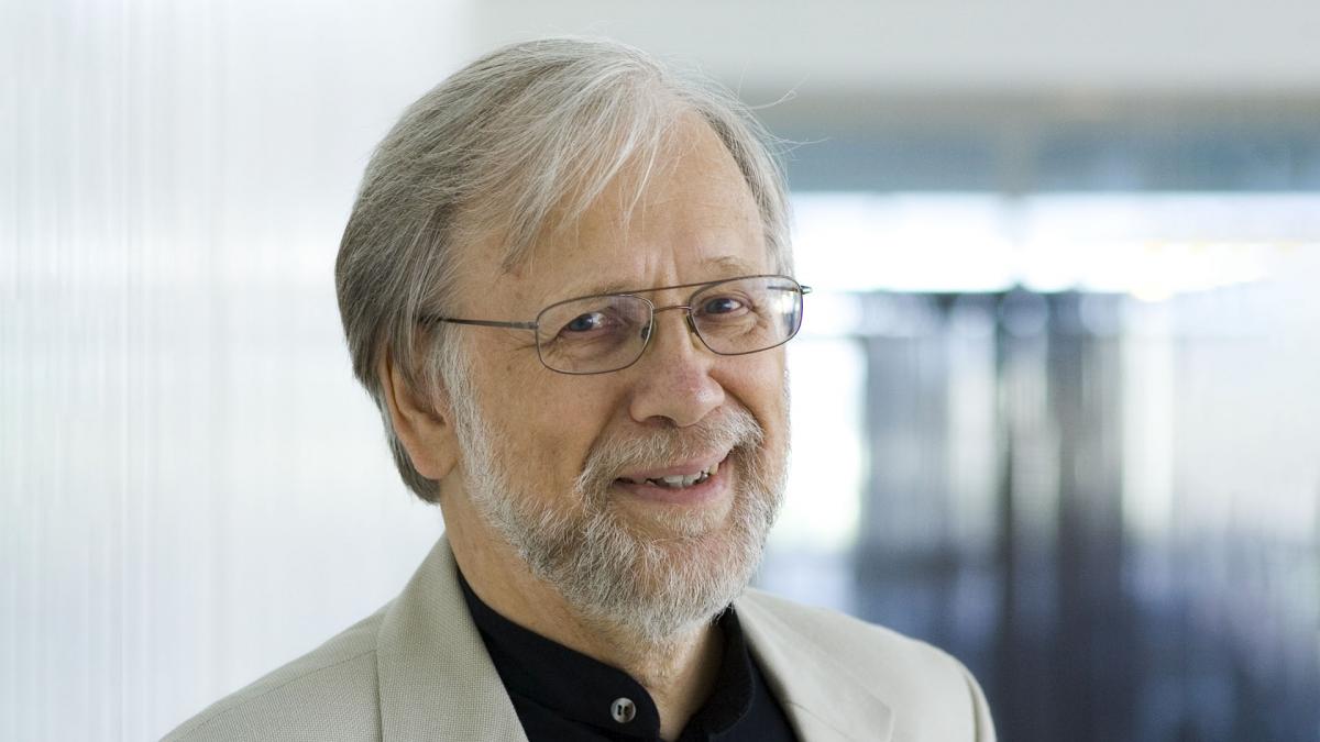 Paavo Heininen smiles at the camera. The picture was taken indoors against a light background.