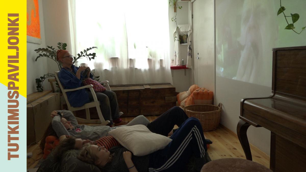 People watching a white screen in living room.