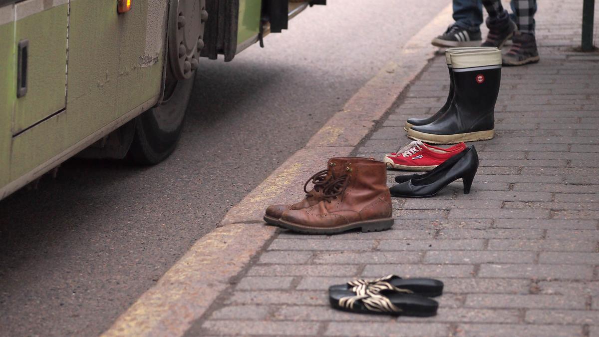 Picture of a shoes that are standing alone at a bus stop