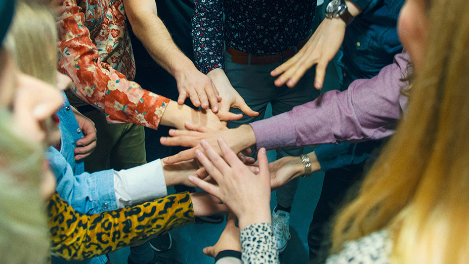 Goupr of people joining hands in a ring