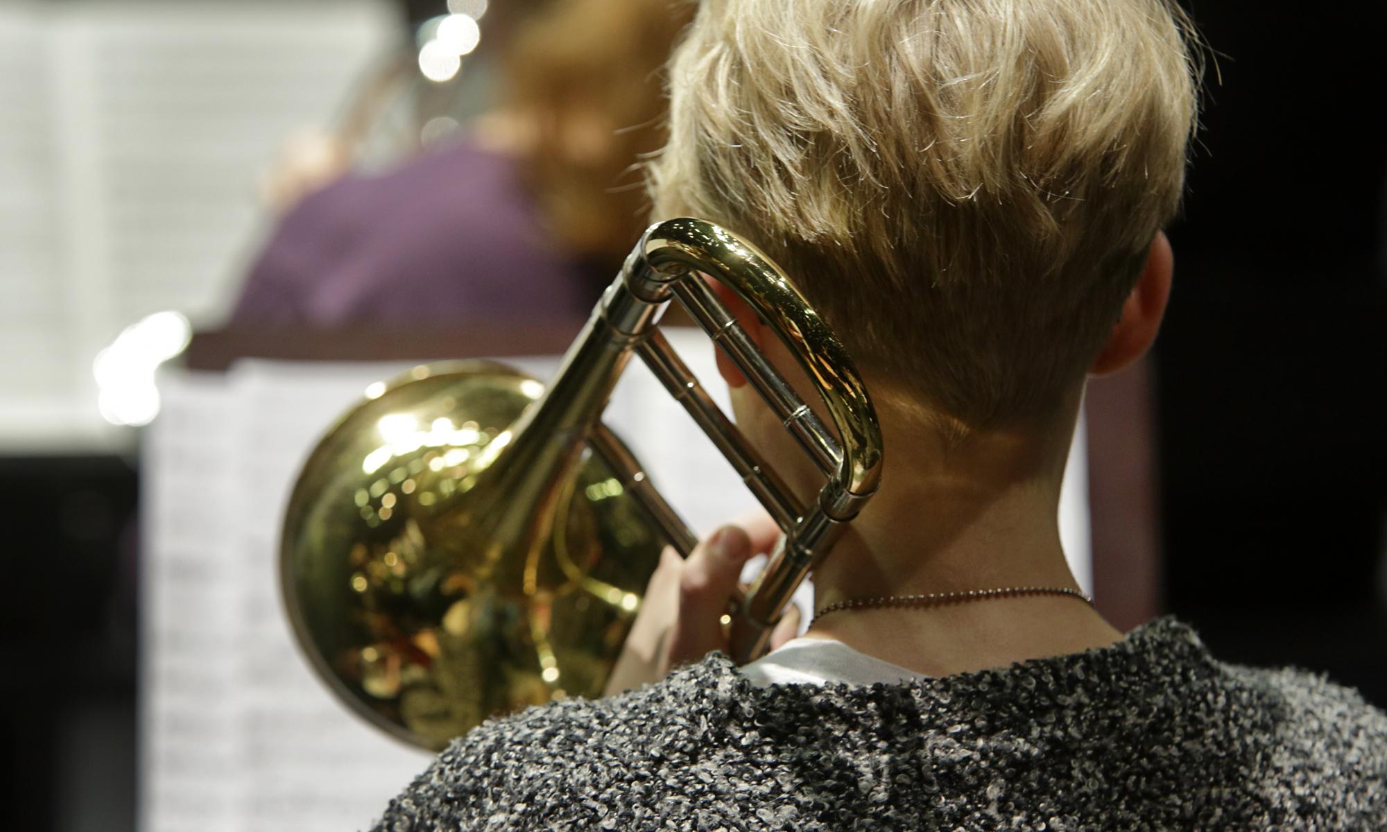 Pasunisti orkesterissa takaapäin kuvattuna