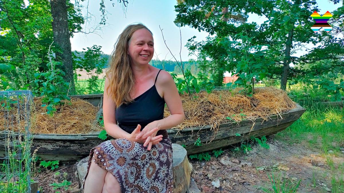 Aune Kallinen sitting in a garden looking off camera.