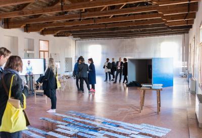 Guests discussing with each other among the works in the exhibitiona at the Research Pavilion opening event in Venice in 2017.
