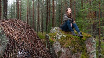 Student Alyssa is sitting in the woods.