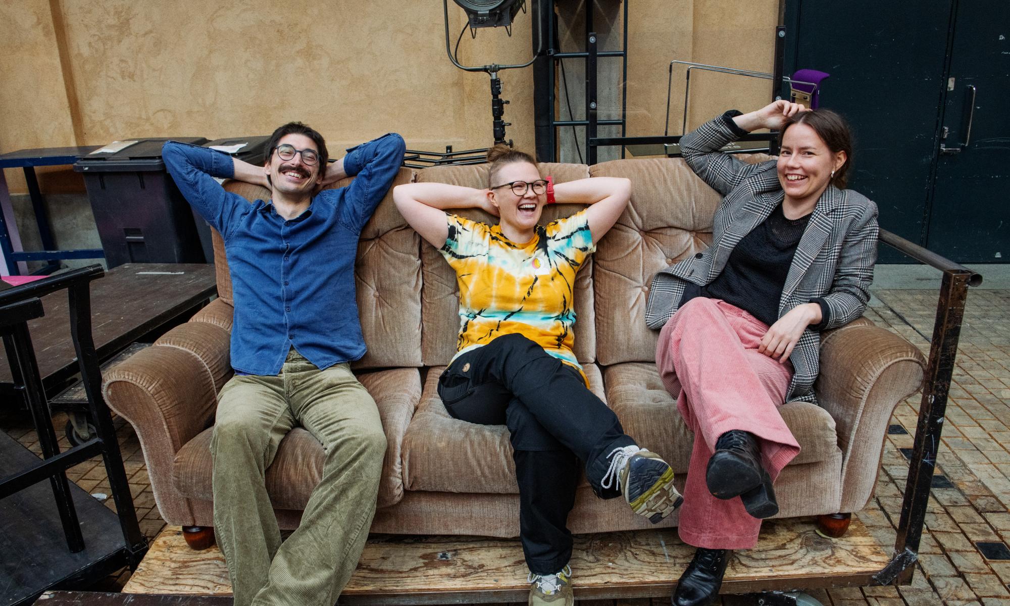 Three people sitting on a coach