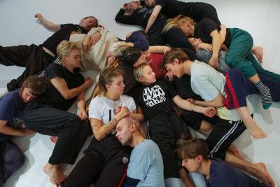 Tanssijaopiskelijoita makaa kasassa eri asennoissa silmät kiinni.