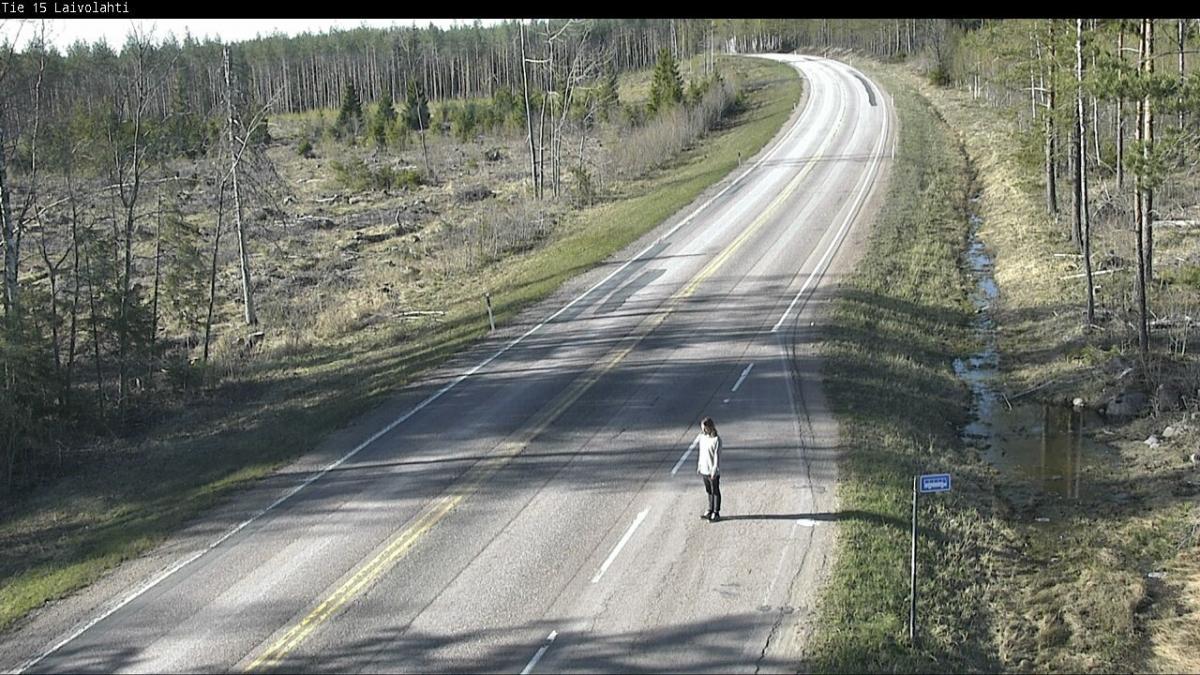 Gustafsson seisoo tien varrella bussipysäkillä keskellä, ympärillä metsää.