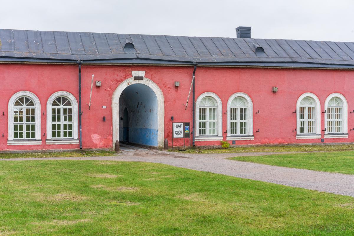 Kuva Suomenlinnan vaaleanpunaisesta pitkästä rakennuksesta, jossa sijaitsevat sekä Galleria Augusta että Pohjoismainen kulttuuripiste.