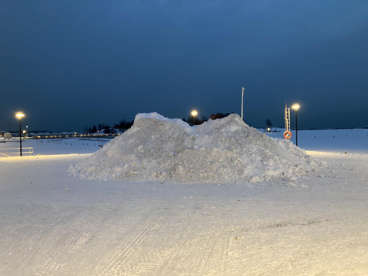A pile of snow, surronded by street lights.