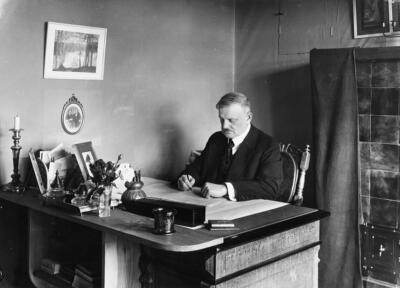 Black and white photo of the composer Jean Sibelius at his desk in his home Ainola.