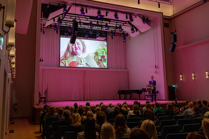 Rehtori Kaarlo Hildén esittelee vuoden alumneja konserttisalin lavalla