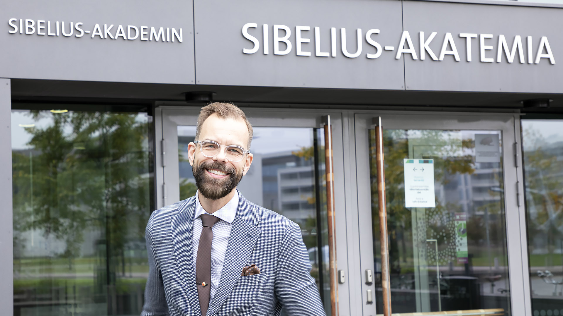 Markus Utrio stands outside of Sibelius Academy's main entrance at Helsinki Music Centre