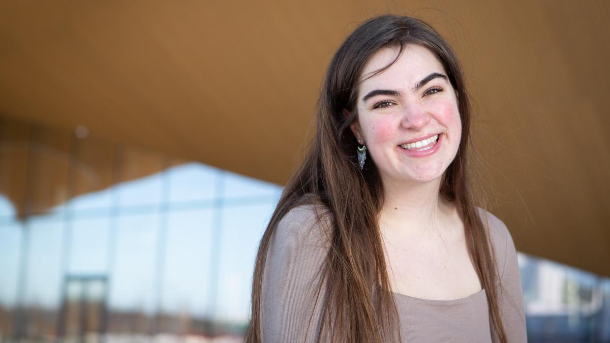 Student Natalie Roe smiles in front of Oodi-library.